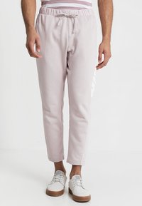 Ljust rosa tapered joggers i strukturerad tyg, med elastisk midja och snörning samt vit accentdetaljer.
