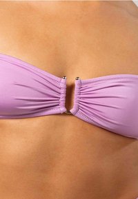 Paars bikini-top met geraffineerde details en een metalen gesp in het midden, gemaakt van glad, rekbaar materiaal.