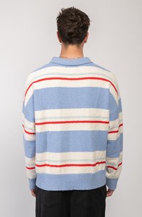 Textured sweater in light blue with horizontal stripes in white, red, and blue. Features a collar and ribbed hem. Back view shown.