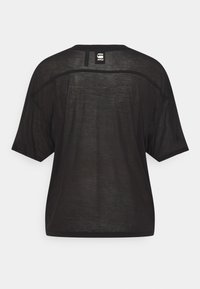 Černé průhledné tričko s krátkým rukávem a širokým výstřihem, s malou bílou štítkovou nášivkou uprostřed horní části zad.