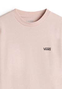 Světle růžové bavlněné tričko s kulatým výstřihem a malým černým logem Vans na levé části hrudi. Hladká textura, minimalistický design.