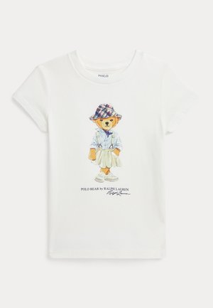 Camiseta de algodón blanca con un gráfico colorido de un oso con un sombrero de cuadros, camisa abotonada, falda y zapatillas, con el texto "Polo Bear by Ralph Lauren".