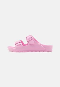 Sandal de slide em EVA rosa com duas correias ajustáveis e uma palmilha texturizada. Apresenta um design moldado e uma sola com ranhuras para melhor aderência.