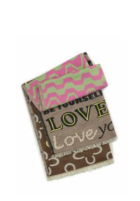 Drie geweven dekens in verschillende kleuren. Bruin met cirkelvormige ontwerpen, roze en groene zigzag, en een tan achtergrond met de tekst "Wees jezelf" en "Liefde."