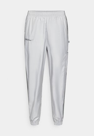 Lichtgrijze sportbroek van gladde stof, voorzien van een elastische tailleband, zijzakken en geborduurde logodetails aan de voorkant.