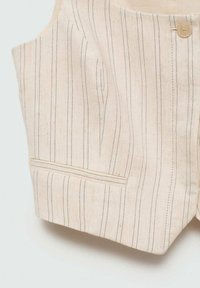 Gilet di lino color beige chiaro con righe verticali scure. Presenta una tasca frontale e una chiusura con un solo bottone, evidenziando dettagli di design sartoriale.
