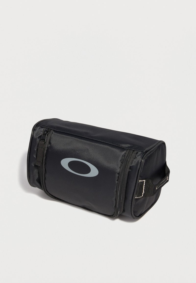 Zwart rechthoekig etui met ritssluiting, zijhandvat en grijs ovaal logo op de voorzak, geplaatst op een lichte achtergrond.