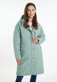 Cappotto lungo trapuntato verde menta con cappuccio, zip frontale e bottoni a pressione. Presenta tasche laterali e una finitura testurizzata.