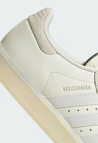 Bijele kožne tenisice s nubuk detaljima, s teksturiranom kremastom potplatom, šavnim detaljima i "VELOSAMBA" logom.