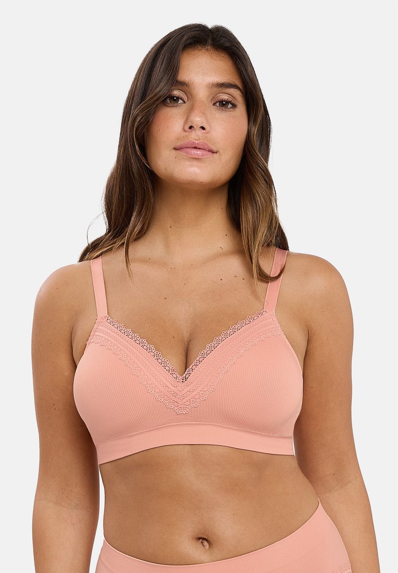Bralette de durazno con canalé y detalle de encaje en el escote y las tirantes. Tejido suave con un diseño en forma de V. Sin aros y elástico para mayor comodidad.