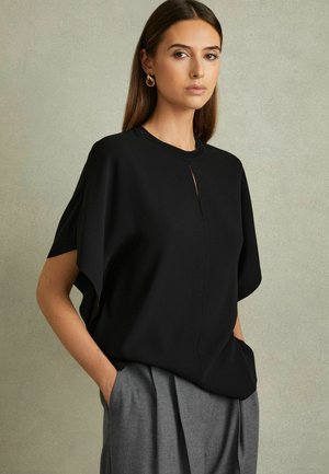 Czarna bluzka o minimalistycznym designie, okrągłym dekolcie i krótkim rękawach. Posiada mały detal w kształcie dziurki z przodu. Gładki materiał.