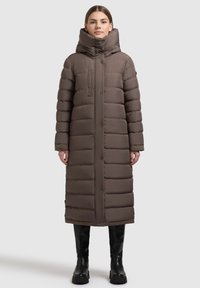 Braune Steppjacke mit hohem Kragen, ausgestattet mit Reißverschluss und Druckknopfverschluss, gesteppte Optik und Seitentaschen. Einfarbige Struktur und knielang.