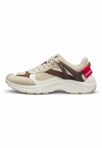 Beige and brown athletic shoe with mesh and synthetic materials, a thick white sole, and a prominent red logo accent on the heel.