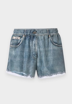 Shorts di denim con vita elastica, orlo sfrangiato, tasche anteriori e una piccola etichetta sulla tasca sinistra su uno sfondo semplice.
