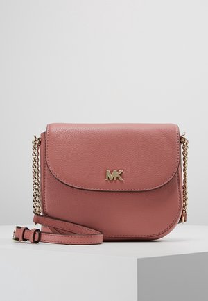 Różowa skórzana torba na ramię z złotym łańcuszkowym paskiem i logo MK na przodzie, przedstawiona na białej powierzchni na jednolitym tle.