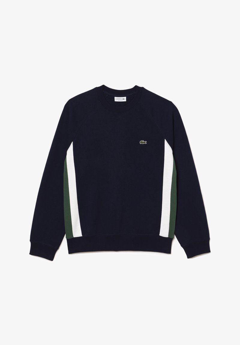 Sweat-shirt à manches longues bleu marine avec des bandes verticales blanches et vertes sur les côtés et un petit logo crocodile vert sur la poitrine.