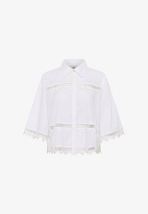 Balta īsām piedurknēm pogājama krekla ar viļņotu apakšmalu un izgriezumiem krūškurvja un piedurknēm apgabalā, kas izgatavots no viegla auduma.