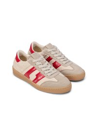 Beżowe sneakersy z czerwonymi skórzanymi akcentami, teksturowaną tkaniną po bokach, białymi sznurowadłami i jasnobrązową gumową podeszwą. Z logo po boku.