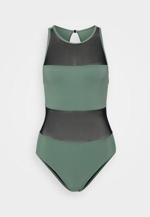 Maillot de bain une pièce en vert doux, avec des panneaux en maille noire transparente. Col haut avec un dos en trou de serrure et tissu extensible lisse.