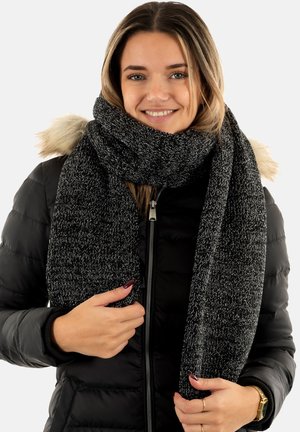 Black and grey textured knit scarf worn loosely around the neck, featuring a soft, thick design suitable for cold weather.