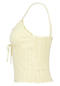 Yellow knitted crop top featuring a textured pattern, adjustable straps, and a scalloped hem. Includes tie details on the side.