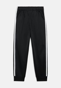 Μαύρο αθλητικό παντελόνι με άνετη εφαρμογή, διαθέτει λευκές ρίγες στο πλάι, ελαστική μέση και ριμπ μανσέτες στους αστραγάλους. Ομαλή υφή.