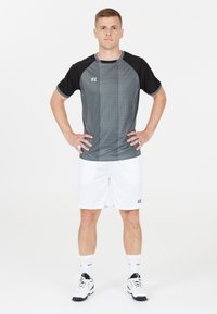 Träningskläder set med en svart och gråmönstrad kortärmad skjorta och vita shorts. Inkluderar FZ-logotyp och lätt, andningsbart material.