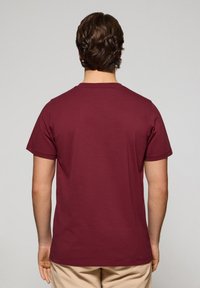 Bordeauxkleurig T-shirt met korte mouwen en een ronde halslijn, gemaakt van zacht katoen, met een casual pasvorm en gedetailleerde stiksels aan de zoom en mouwen.