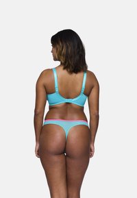 Conjunto de sujetador y tanga de color azul claro con acentos rosas, que cuenta con tirantes ajustables, tejido texturizado y un diseño seamless.
