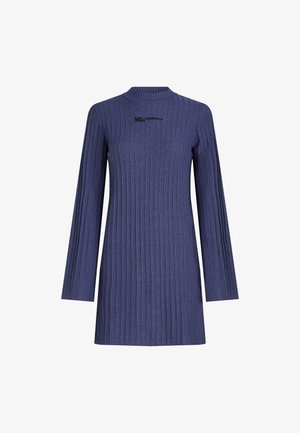 Tumši zils ribota adījuma kleita ar augstu kakla izgriezumu un garām piedurknēm. Priekšpusē ir smalks melns izšūts logotips.