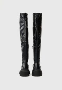 Čierne vysoké čižmy nad kolená vyrobené z hladkej kože, s priliehavým strihom, hrubými podrážkami a skrytými zipsami po bokoch.