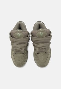 Πράσινα αθλητικά παπούτσια με υφασμάτινη επένδυση, στρογγυλή μύτη και χοντρές κορδόνες. Διαθέτουν ανάγλυφο λογότυπο και σχεδιαστικά στοιχεία σε πιο ανοιχτό τόνο.