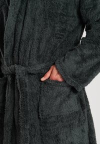 Peignoir de bain en velours gris foncé avec une surface douce et texturée, doté d'une ceinture à nouer et de poches latérales pour plus de commodité.