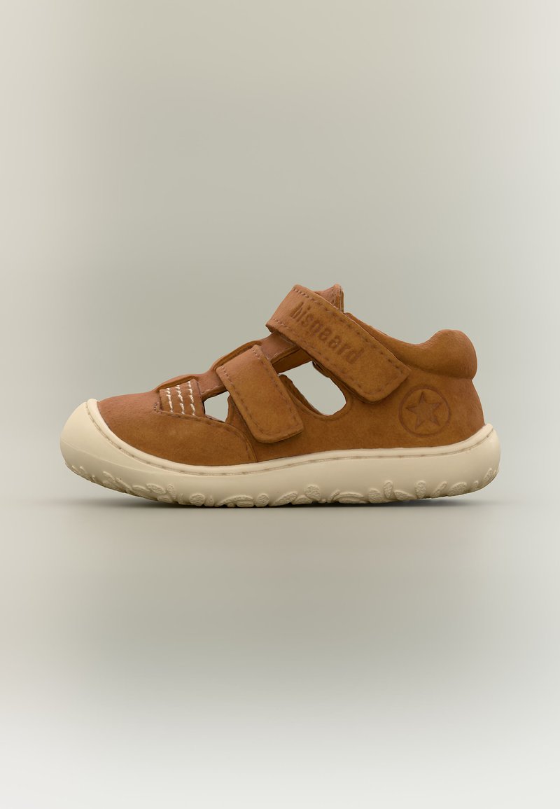 Sandale marron pour enfants à bout fermé avec deux brides velcro, emblème étoile sur le talon et semelle en caoutchouc blanche texturée sur fond uni.