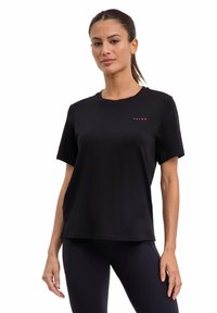 Zwart katoenen T-shirt met korte mouwen, ronde hals en een subtiel rood logo op de borst. Zachte textuur en een ontspannen pasvorm.