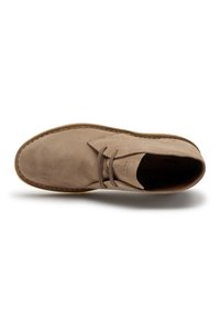 Stivaletto chukka in suede beige con punta tonda, design alla stringa, cuciture tono su tono e suola in gomma marrone chiaro.