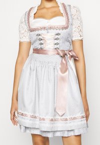 Robe dirndl gris clair avec manches courtes en dentelle, accents décoratifs roses, devant style corset et ceinture en ruban de satin à la taille.