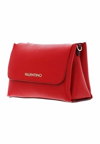 Bolso de mano de cuero rojo con una superficie texturizada, solapa plegable, herrajes dorados y un logotipo embellecido en la parte frontal. Diseño compacto y estructurado.