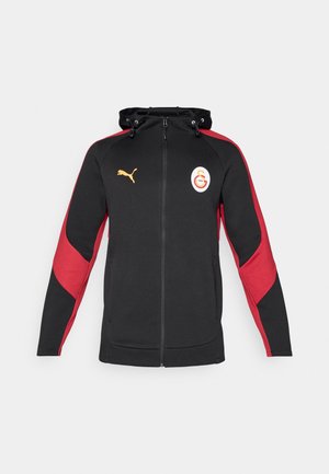 Musthave musta kapuutsiga, millel on punased aktsendid, ees tasku, reguleeritav kapuuts ja trükitud logo. Valmistatud pehmest kangast, sportliku disainiga.