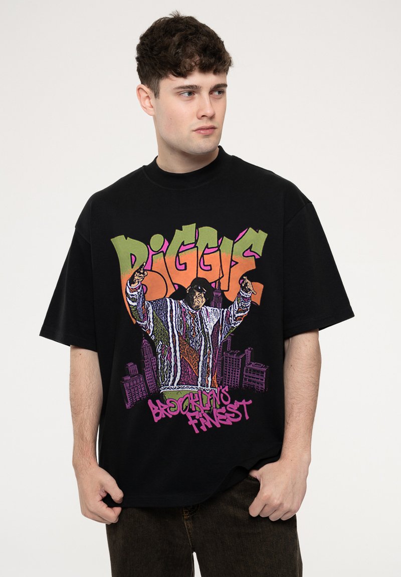 Black oversized T-shirt featuring a colorful graphic of a figure in a striped sweater with text "B.I.G." and "Brooklyn's Finest" in bold colors.