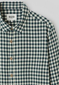 Chemise à carreaux verts et blancs avec un col, dotée de quatre boutons marron et d'un tissu texturé. L'étiquette de la marque indique "BZB" et la taille "L".