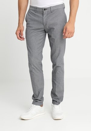 Grijze met een patroon broek met een slim fit ontwerp, uitgerust met een knoopsluiting en zakken, gecombineerd met witte sneakers.