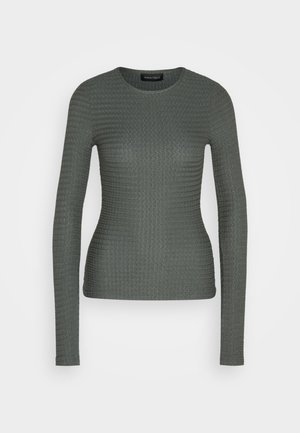 Hosszú ujjú, kerek nyakú felső sötétzöld színben, texturált anyagból, bordázott mintával. Testhez simuló fazon, diszkrét kialakítás, látható fémalkatrészek nélkül.