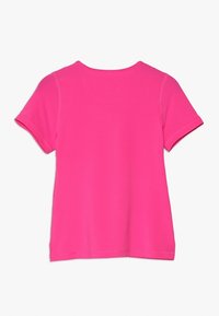 Camiseta de manga corta en rosa brillante, con textura acanalada, cuello redondo y un corte relajado con detalles de costura.
