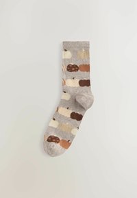 Harmaat sukat, joissa on erilaisia värikkäitä kurpitsoja ruskean, kerman ja orangein sävyin. Pehmeä neulepinta.