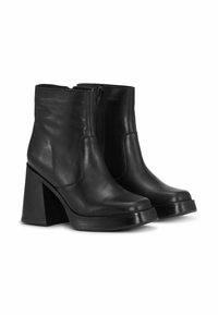 Černé kožené kotníkové boty s hladkým povrchem, vysokým blokovým podpatkem, zaoblenou špičkou a postranním zipem.