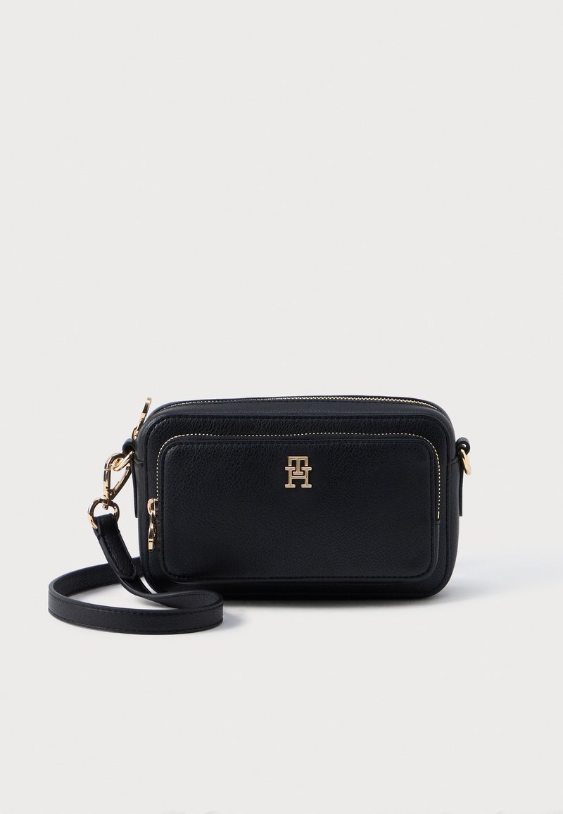 Černá kožená crossbody taška se dvěma zipovými oddíly, zlatým kováním, odnímatelným popruhem a vyraženým logem na přední straně.