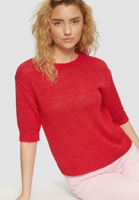 Roter kurzärmeliger Pullover aus strukturiertem Strickstoff, mit rundem Ausschnitt und gerippten Bündchen sowie Saum.