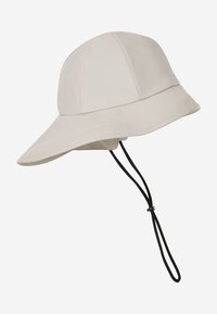 Chapeau d'extérieur beige clair à larges bords avec sangle noire réglable sous le menton et panneaux en tissu lisse pour protection solaire.