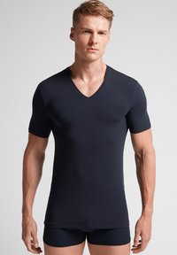 Męska dopasowana koszulka V-neck w kolorze granatowym, wykonana z gładkiego materiału, z krótkimi rękawami i prostym, minimalistycznym wzorem. Akcent na kształcie dekoltu.